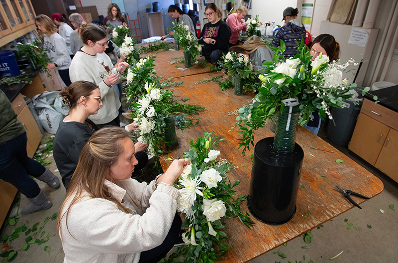 Students work on floral bouquets in lab