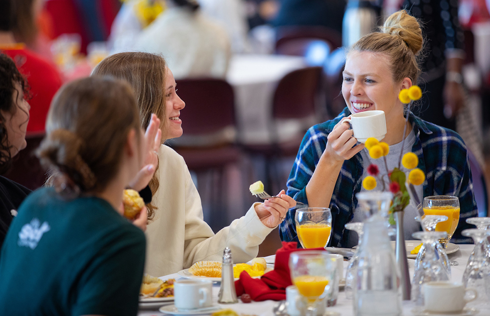 Female students share conversation at breakfast