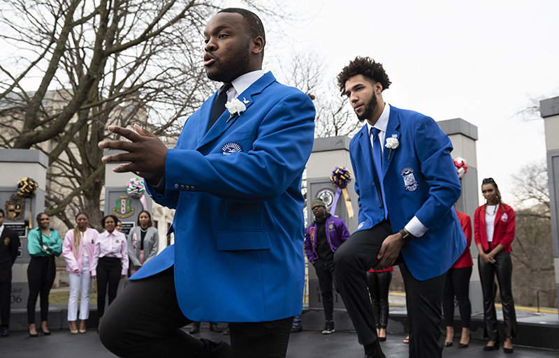 Two males participate in a dance on the plaza