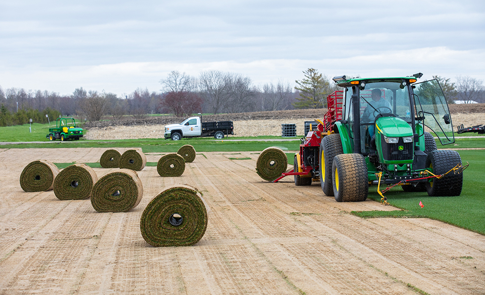 A sod cutting machine expels a completed roll