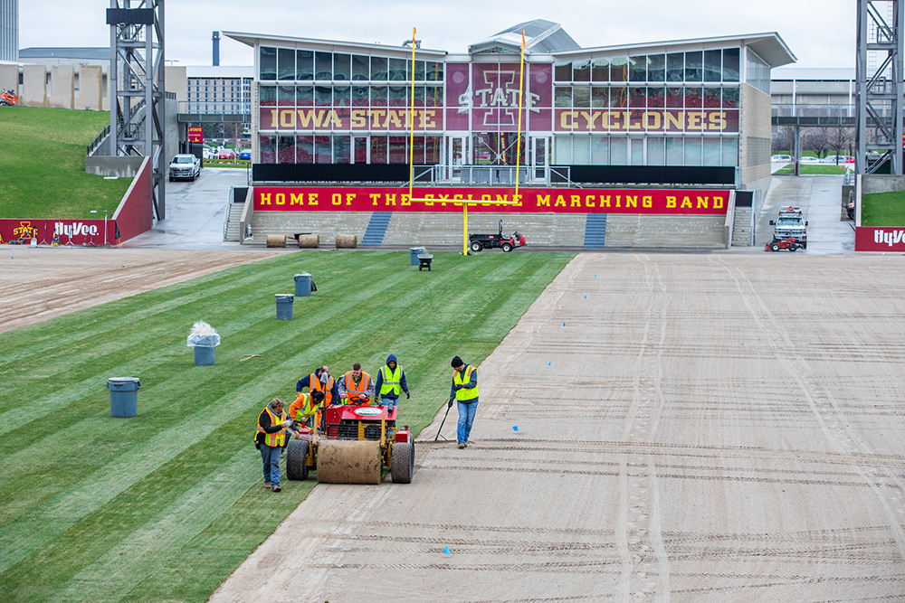 Endzone view of sod unrolling on Jack Trice field
