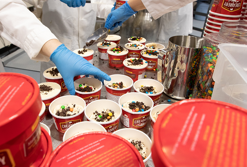 Candies being added to ice cream containers