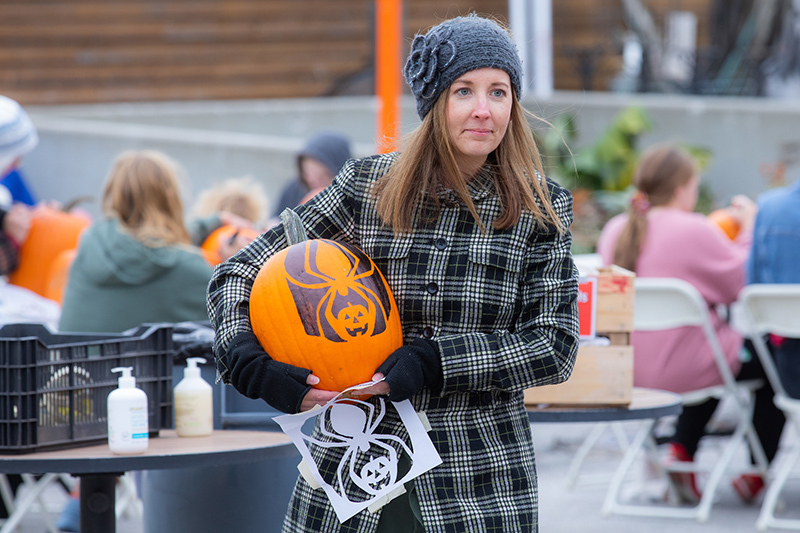 Liz Harris carries a stenciled pumpkin