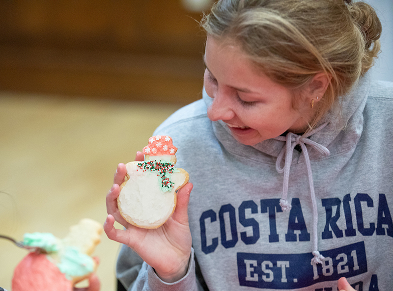 Female student shows off a frosted snowman cookie