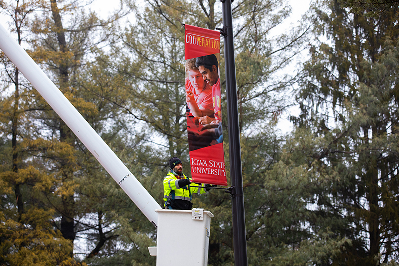 Kurt Garretson adjusts "cooperation" banner on light pole