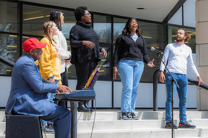 Students sing on the Parks Library steps