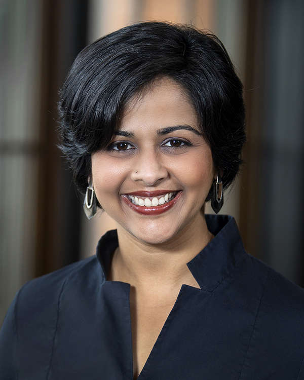 Head shot of woman with black hair in navy blouse