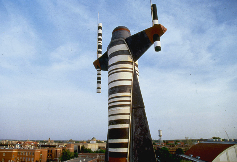 Metal gnome sculpture atop campus roof