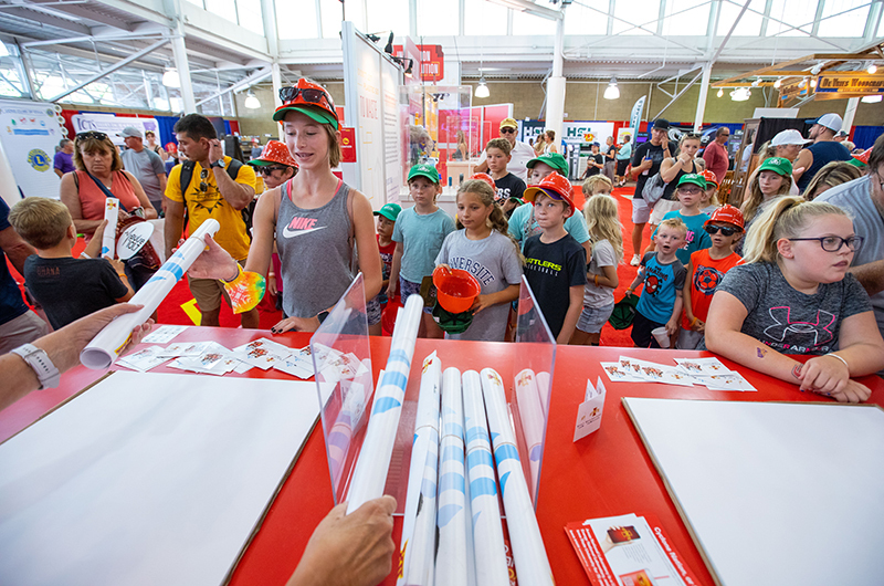 Youth pick up schedule posters at the ISU exhibit during the 202